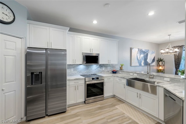 kitchen with light hardwood / wood-style flooring, stainless steel appliances, tasteful backsplash, white cabinets, and sink