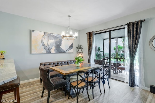 dining area featuring light hardwood / wood-style flooring and a chandelier