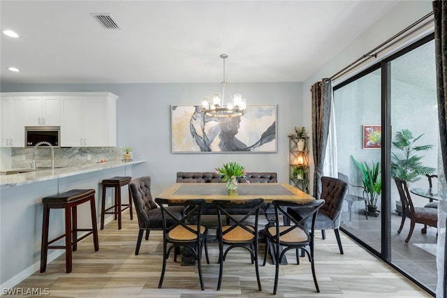 dining space featuring an inviting chandelier and light hardwood / wood-style flooring