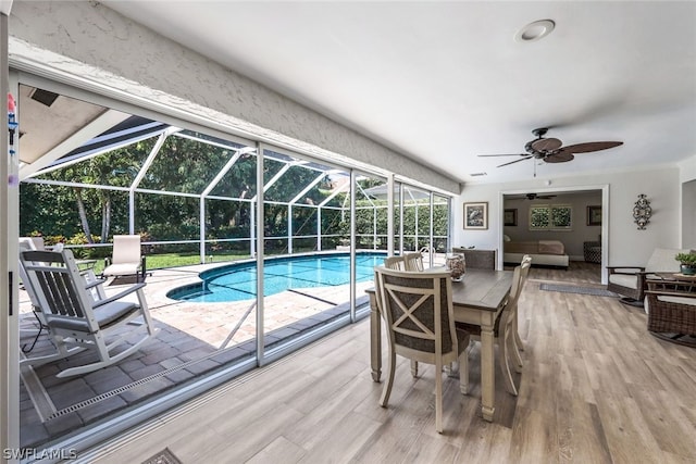 view of swimming pool featuring a patio area, ceiling fan, an outdoor hangout area, and glass enclosure