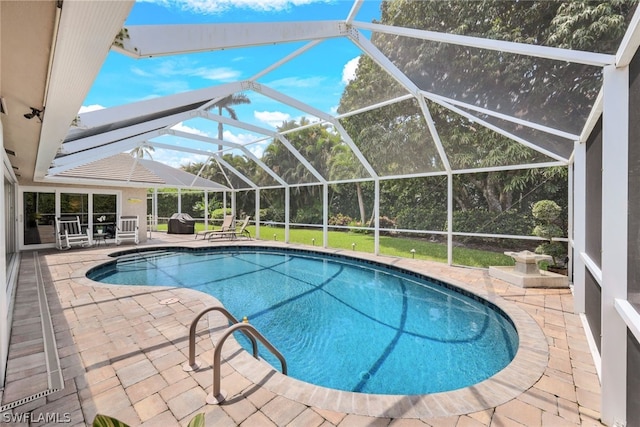 view of swimming pool featuring a patio and glass enclosure