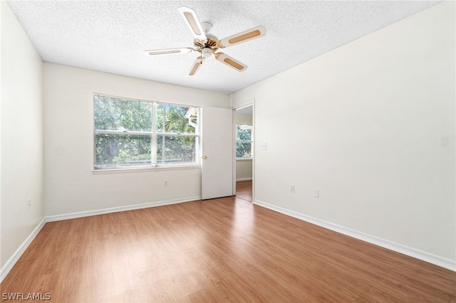 unfurnished room featuring a textured ceiling, light hardwood / wood-style floors, and ceiling fan