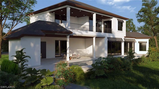 rear view of house featuring a balcony and a patio