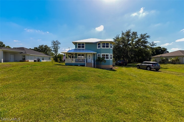 rear view of property with a porch and a yard