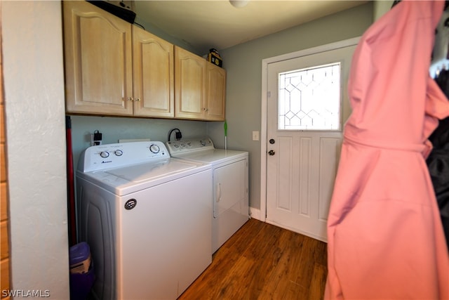 washroom featuring dark hardwood / wood-style floors, cabinets, and washer and dryer