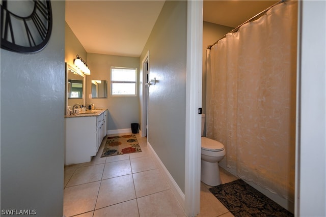 bathroom featuring tile flooring, vanity with extensive cabinet space, and toilet