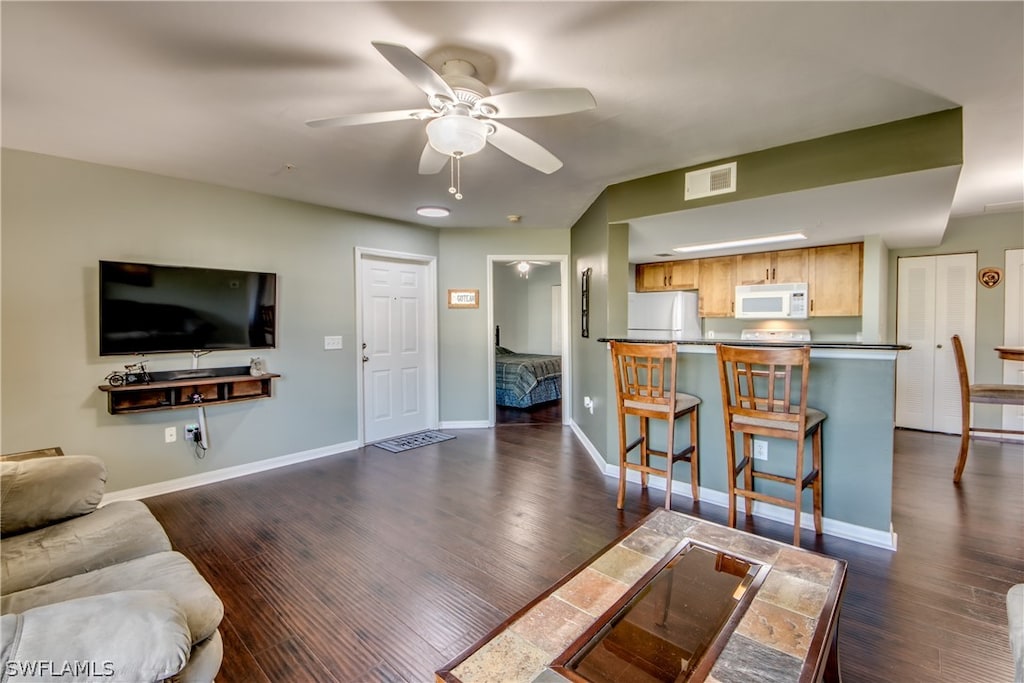 living room with ceiling fan and dark hardwood / wood-style floors