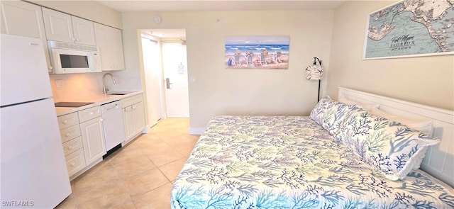 bedroom featuring a closet, sink, white fridge, and light tile patterned flooring