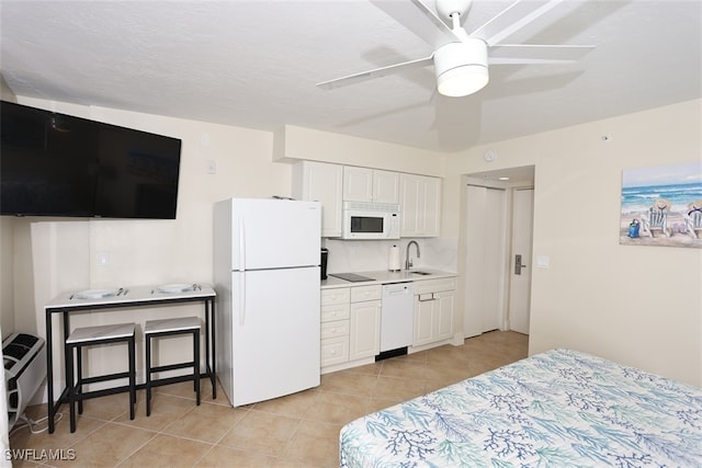 tiled bedroom featuring ceiling fan, sink, and white fridge