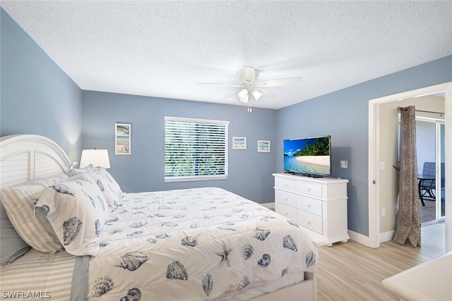 bedroom featuring ceiling fan, light hardwood / wood-style floors, and a textured ceiling