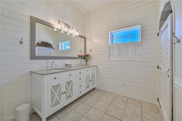 bathroom featuring tile patterned floors, vanity, and wooden walls