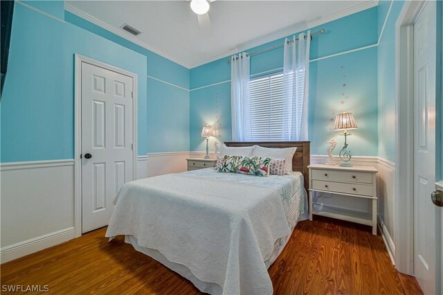 bedroom featuring hardwood / wood-style flooring, ceiling fan, and ornamental molding