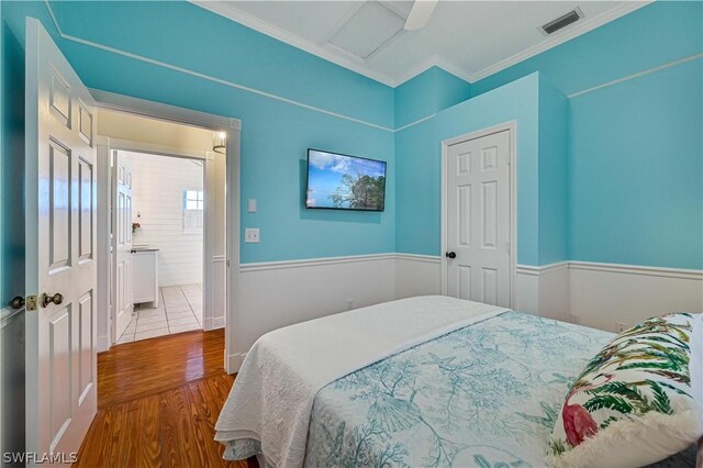 bedroom featuring ceiling fan, light hardwood / wood-style flooring, and crown molding