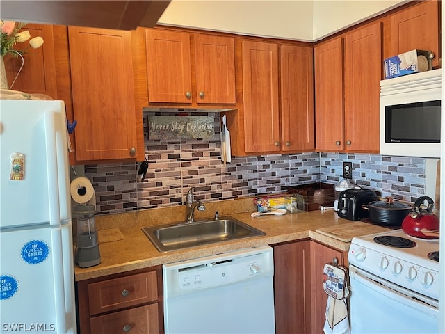 kitchen featuring backsplash, white appliances, and sink