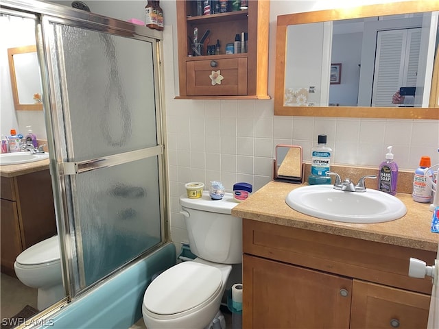 full bathroom with tile walls, oversized vanity, toilet, enclosed tub / shower combo, and tasteful backsplash