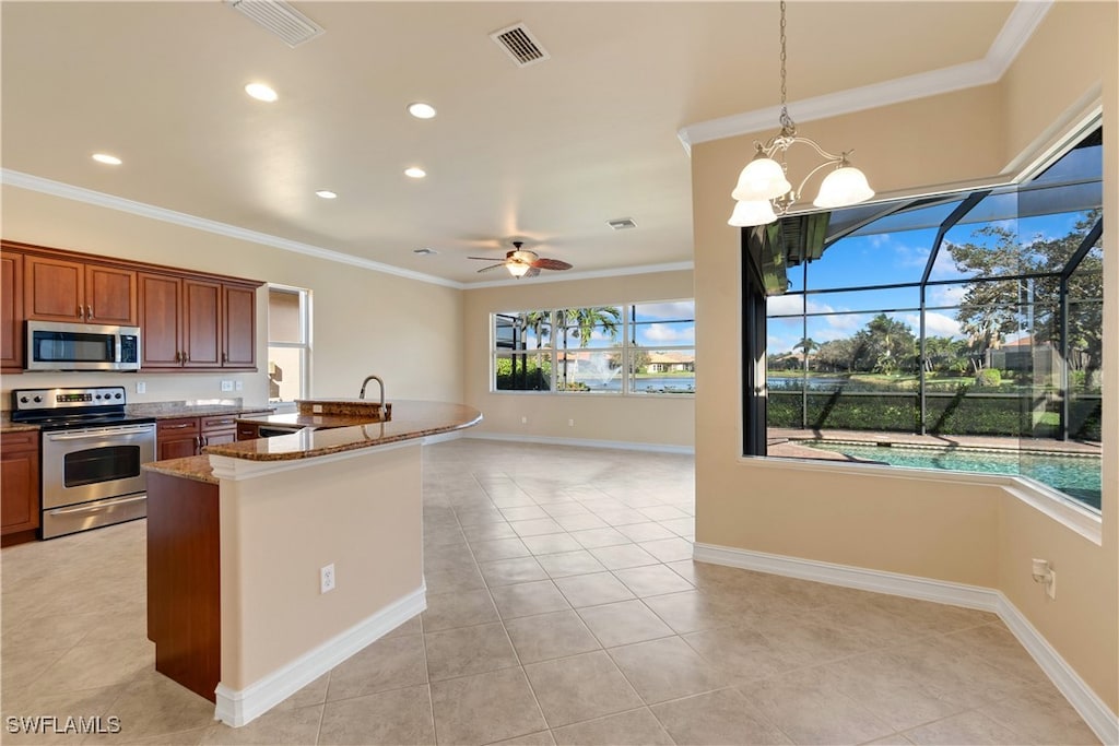 kitchen with stainless steel appliances, light tile patterned flooring, stone countertops, and decorative light fixtures