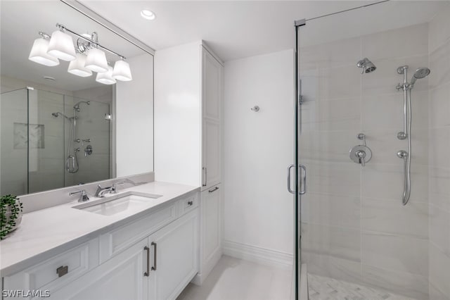 full bath with a stall shower, baseboards, and vanity