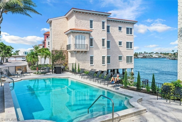 community pool with a patio area and fence