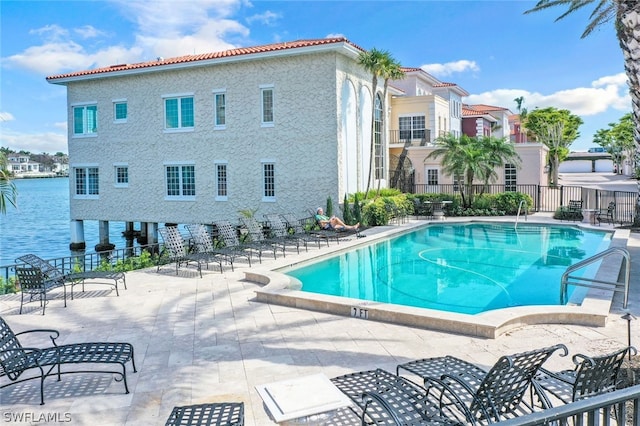 community pool with a patio area and fence