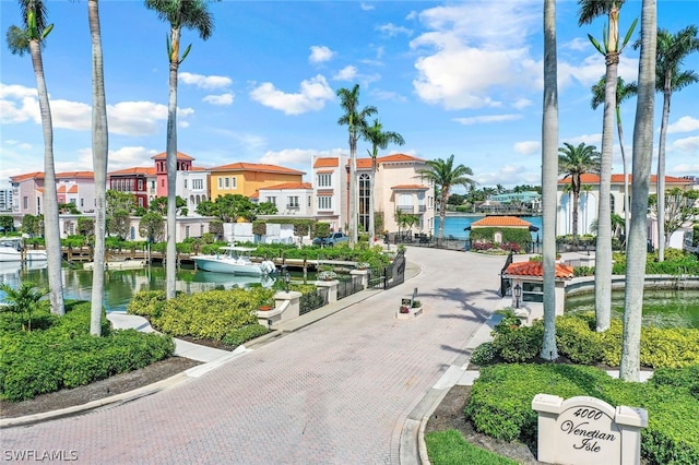 view of street featuring curbs, a water view, and a residential view