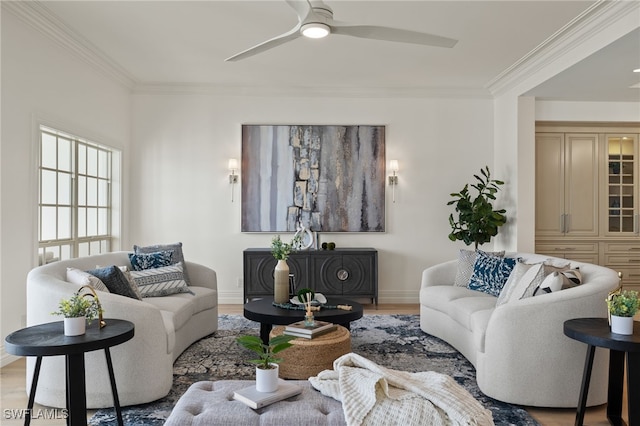 living area with ceiling fan, ornamental molding, wood finished floors, and baseboards