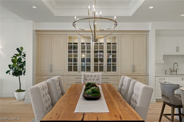 dining area featuring a chandelier, a raised ceiling, and crown molding