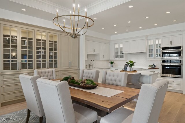 dining room featuring crown molding, recessed lighting, an inviting chandelier, and light wood-style floors