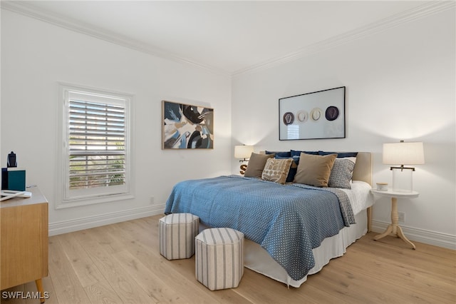 bedroom with light wood-style flooring, ornamental molding, and baseboards