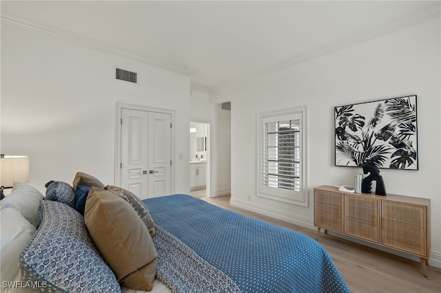 bedroom with baseboards, light wood-style flooring, visible vents, and crown molding