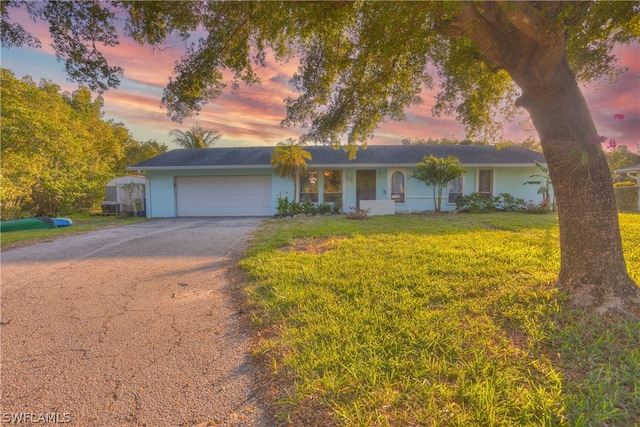 single story home with a garage and a lawn