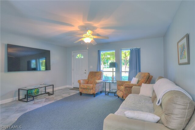 carpeted living room with ceiling fan