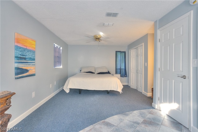 carpeted bedroom with a textured ceiling and ceiling fan