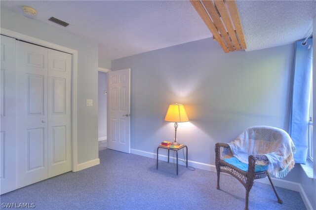 living area with dark carpet and a textured ceiling