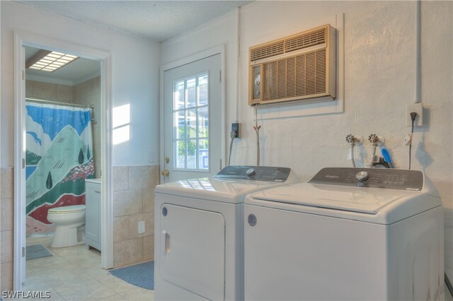 laundry room featuring tile walls, light tile flooring, hookup for a washing machine, independent washer and dryer, and hookup for an electric dryer