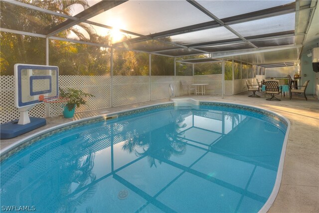 view of swimming pool with a patio area and glass enclosure