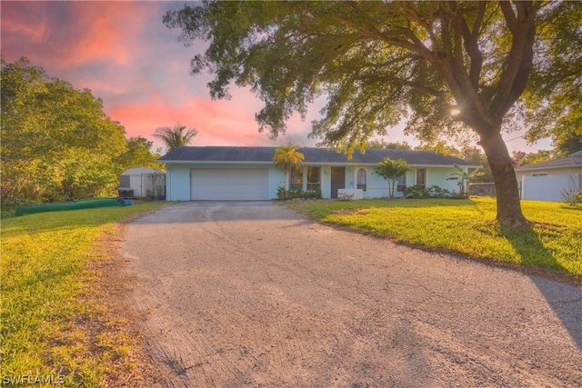 ranch-style home featuring a yard and a garage