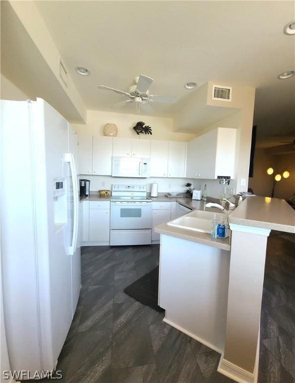 kitchen with kitchen peninsula, white appliances, ceiling fan, sink, and white cabinets