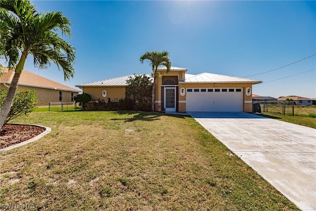 view of front of property featuring metal roof, an attached garage, concrete driveway, stucco siding, and a front lawn