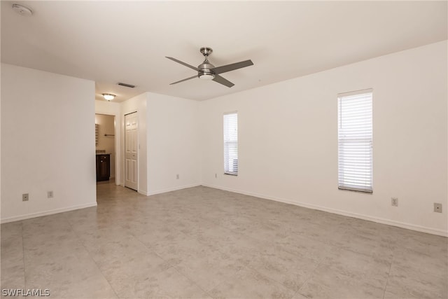 tiled spare room featuring ceiling fan and a healthy amount of sunlight