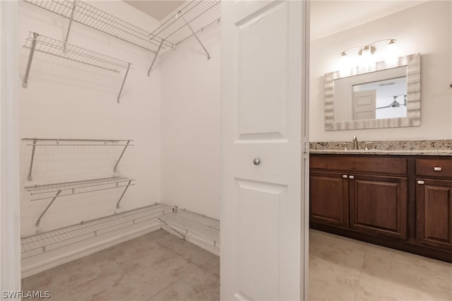 spacious closet with sink and light tile floors