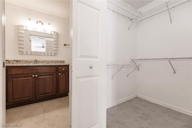 spacious closet with sink and light tile flooring