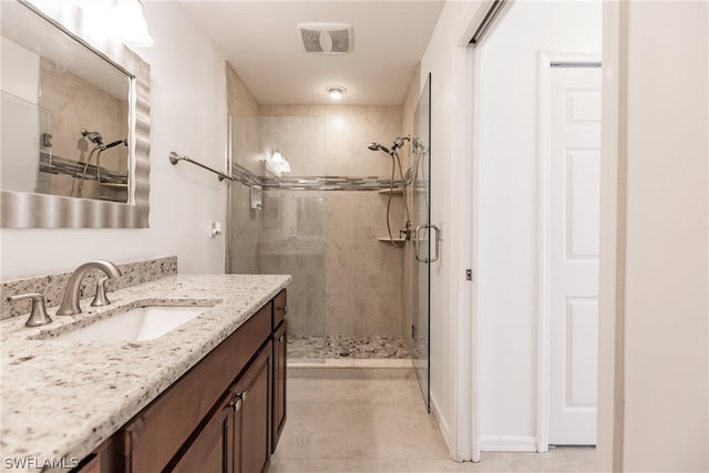 bathroom with an enclosed shower, vanity, and tile flooring