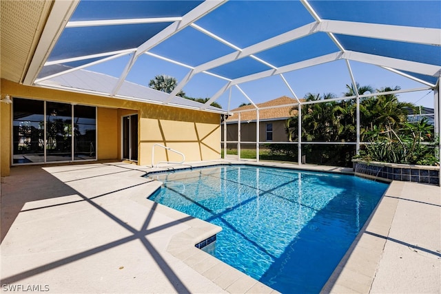 view of swimming pool featuring a patio area and glass enclosure