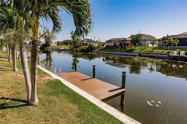 dock area featuring a water view, a lanai, and a lawn