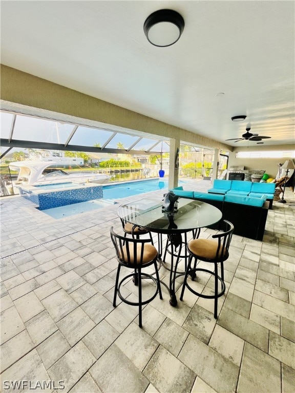 view of patio / terrace featuring outdoor lounge area, a swimming pool with hot tub, glass enclosure, and ceiling fan