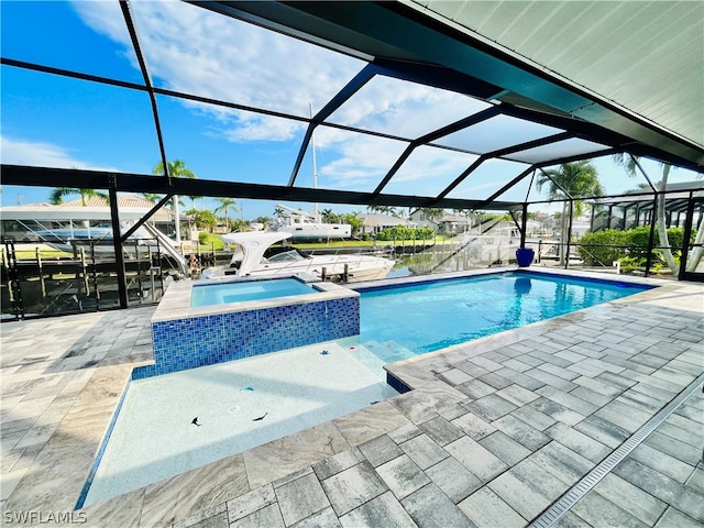 view of pool with an in ground hot tub, a patio, a water view, and a lanai