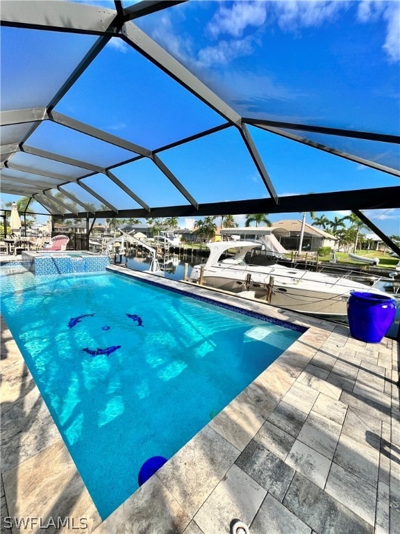 view of pool featuring glass enclosure, a water view, a patio, and a boat dock