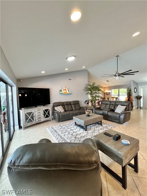 tiled living room with ceiling fan and lofted ceiling