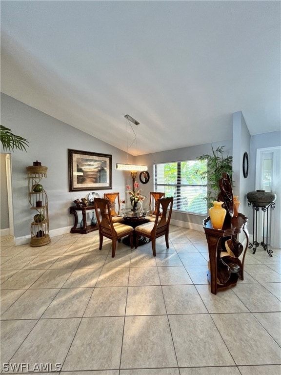 dining area featuring light tile patterned floors and lofted ceiling