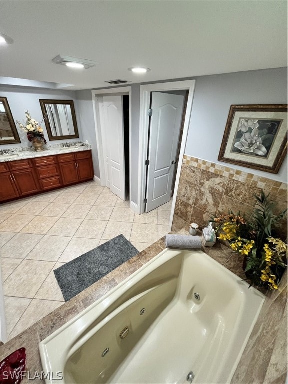 bathroom featuring tile patterned flooring, vanity, and a tub to relax in